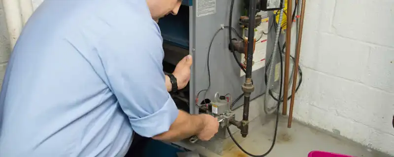 Furnace repair technician inspecting and servicing a home heating system in San Mateo, CA