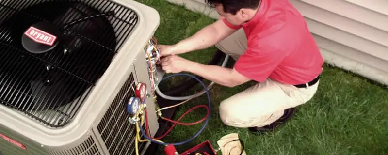 HVAC technician servicing an outdoor air conditioner unit in San Mateo, CA