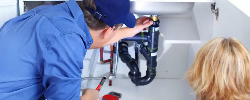 Plumber repairing under-sink drain pipes and fittings in San Mateo, CA